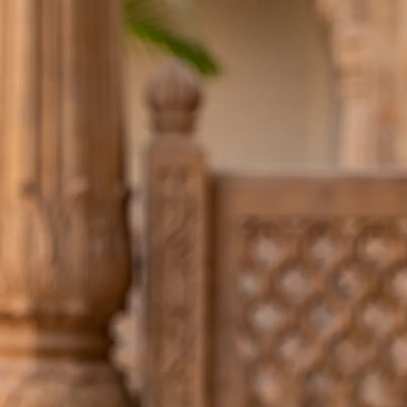 A carved sandstone pillar and jali screen in a haveli courtyard